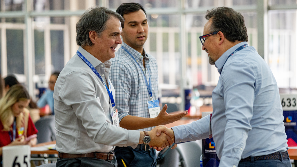 Empresarios se saludan durante una rueda de negocios realizada en Expocamacol 2026 en Medellín.
